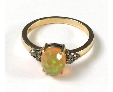 Ring punziert 585. Opal beidseitig eingeschlossen von jeweils drei Diamanten á 0,02 ct. Opalgröße ca. 7 x 9 x 4,5 mm. Ringgrö