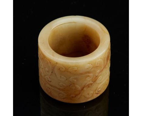 A well carved 17th c. Chinese russet jade archer's ring with a fine curling pattern carved in subtle relief. Traces of red la