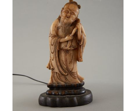 An an elegant and early soapstone carving of a figure. Carved in China in the 19th century, it was mounted as a lamp in Ameri