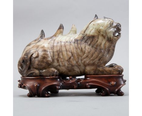 A large Chinese grey jade carving of a foo dog, well carved of a mottled grey stone. On a well carved Chinese wooden stand. P