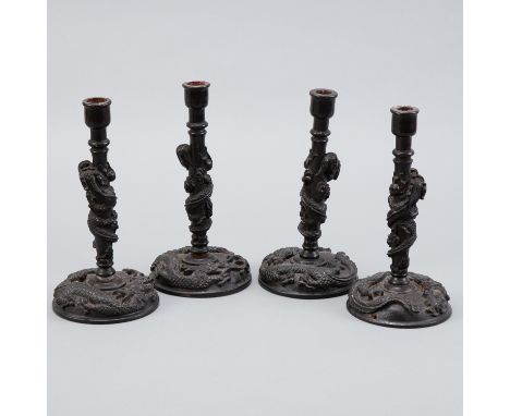 A very unusual set of four Chinese rosewood candle sticks carved with dragons and all able to be unscrewed into two parts. Th