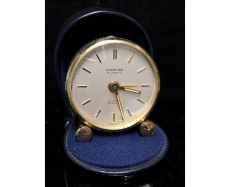 A Looping Travel Alarm clock, blue enamel finish 15 jewel 8 day movement, in leather horseshoe shaped case (2)