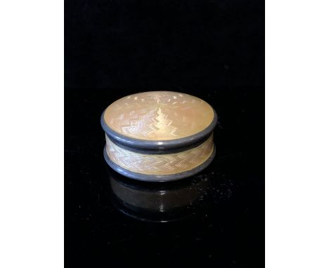 An enamelled pill box, circular, the box engine turned and enamelled in pale peach, the lift off cover opening to reveal a si