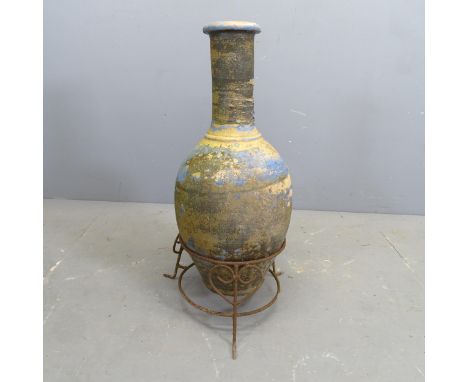 A vintage blue painted terracotta vase on wrought iron stand. H - 76cm. 
