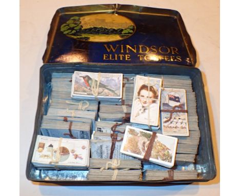 Vintage tin containing a quantity of Wills cigarette cards 