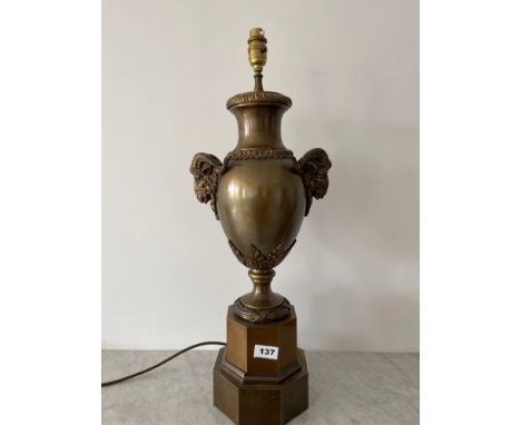An antique French bronzed metal table lamp with goat head embellishment, H. 63cm.