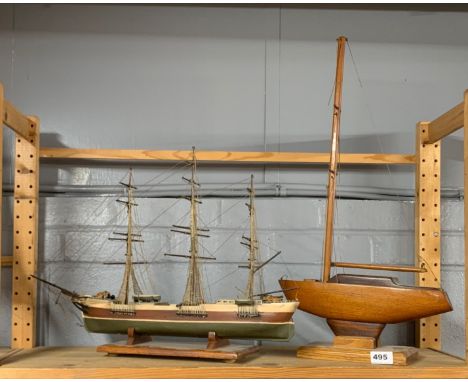 A vintage mahogany model of a yacht, 32 x 61cm, together with a further model of a three masted schooner.