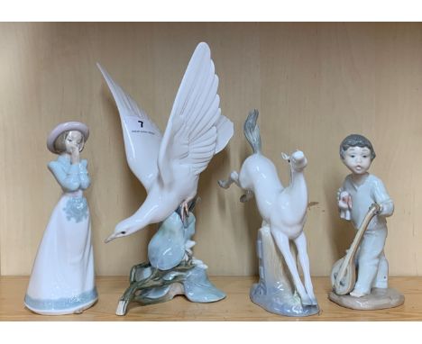 A Lladro figure of a dove, H. 27cm (tiny chip to wing), together with two Nao figures of children and a further Spanish figur