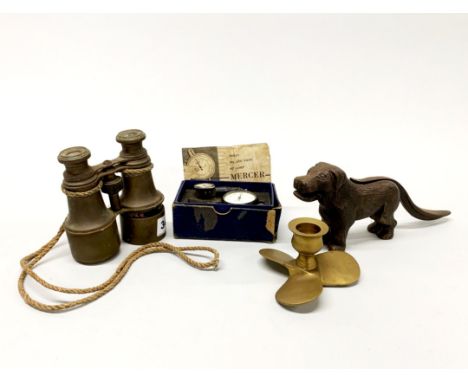 A pair of antique brass field glasses and a map reading dial gauge, a cast iron dog nutcracker and a brass propeller candle s