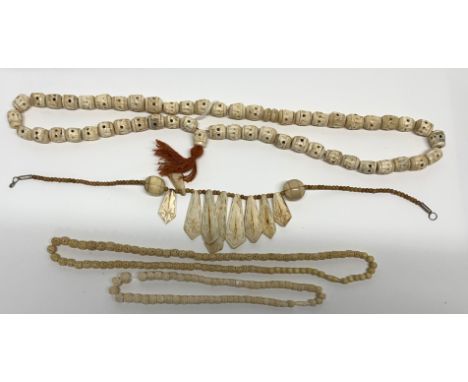 A group of carved bone necklaces.