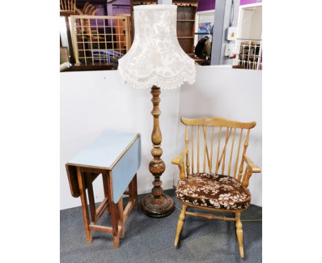 A formica topped drop leaf table, a standard lamp with shade and a rocking chair.