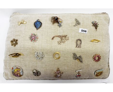 A cushion of vintage costume brooches.