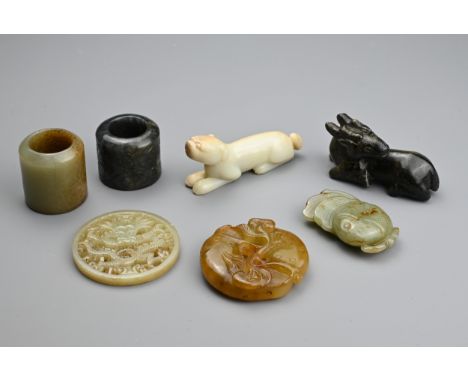 SEVEN CHINESE CARVED JADE ITEMS. Comprising: a celadon stylised fish pendant, a circular pendant pierced with a dragon, a mot