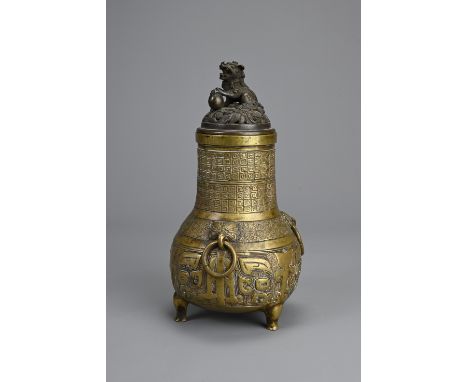 A CHINESE BRONZE TRIPOD JAR AND COVER, 18/19TH CENTURY. Globular body supported on three feet with phoenix head ring handles 