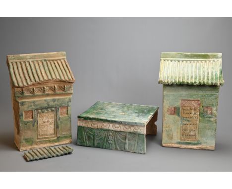 TWO CHINESE MING DYNASTY (1368-1644) POTTERY MODELS OF HOUSES AND A BASE, each glazed in green, modelled with a sloping roof,