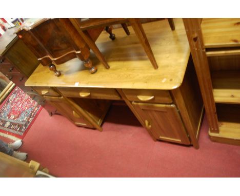 A contemporary light oak round cornered kneehole writing desk, having three frieze drawers over conforming cupboard doors, w.