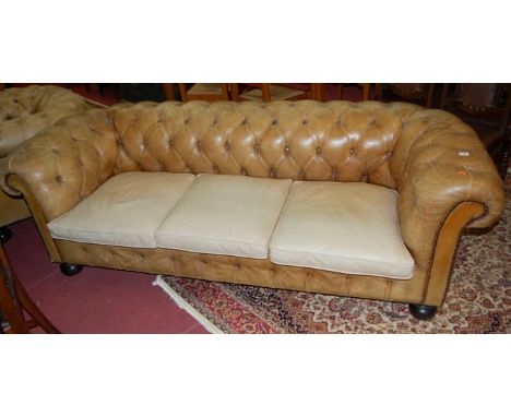 A Victorian style faded tan leather button back and brass studded three-seater Chesterfield, width 200cm