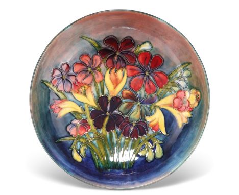 A WALTER MOORCROFT FLAMBÉ&nbsp;POTTERY BOWL, shallow&nbsp;form, 'Spring Flowers' pattern, tubelined and painted in tones of r