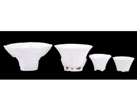 FOUR CHINESE DEHUA CUPS, including one moulded with prunus and another moulded with animals and prunus. (4) Largest 13cm wide