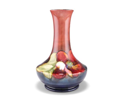 A WALTER MOORCROFT FLAMBÉ&nbsp;POTTERY VASE, squat baluster form with a long flared neck, 'Clematis' pattern, tubelined and h