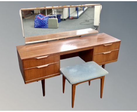 An Austinsuite teak twin pedestal dressing table with mirror on raised legs (width 147cm), with matching stool.
