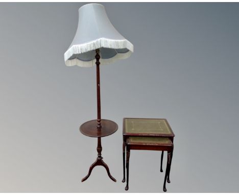 A nest of two glass and leather topped tables together with a stained beech standard lamp/occasional table with shade.