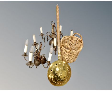 Two continental brass five way light fittings together with a wicker twin handled basket and bed warming pan.