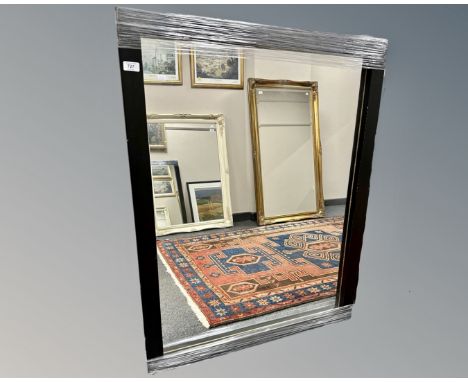 A contemporary mirror in a black frame, 86cm by 111cm.