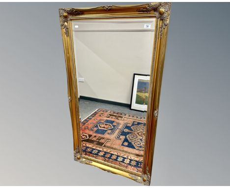 A gilt framed bevelled mirror, 75cm by 137cm.