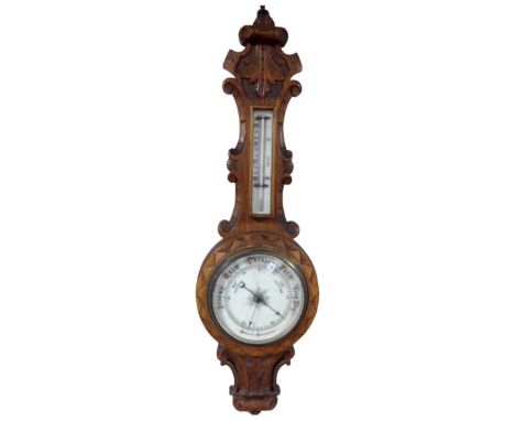 An Edwardian carved oak aneroid barometer.