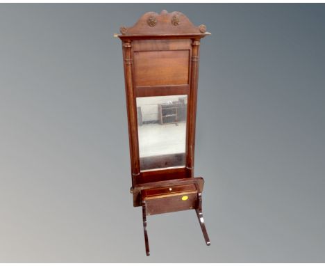 An antique mahogany wall mirror together with wall shelf fitted with a drawer.