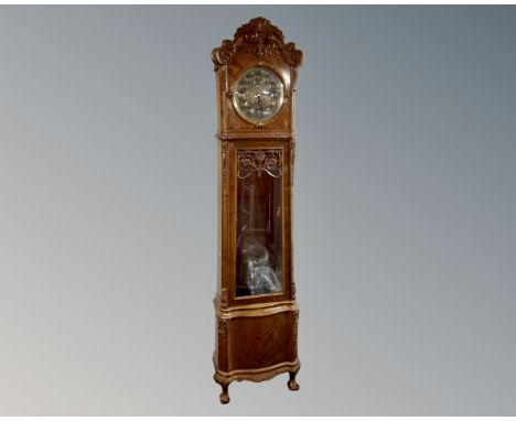 A Continental beech longcase clock with brass embossed dial, pendulum and weights.