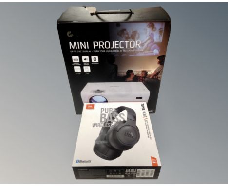 A Goodmans mini projector together with a set of JBL Pure Bass wireless headphones, both parts boxed.