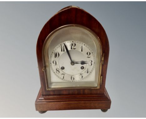 A teak Junghans bracket clock with silvered dial on ball feet 
