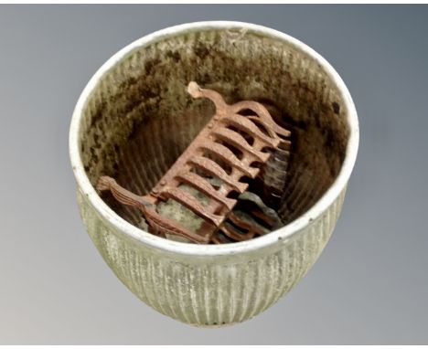 A galvanized metal wash tub together with a cast iron fire grate.