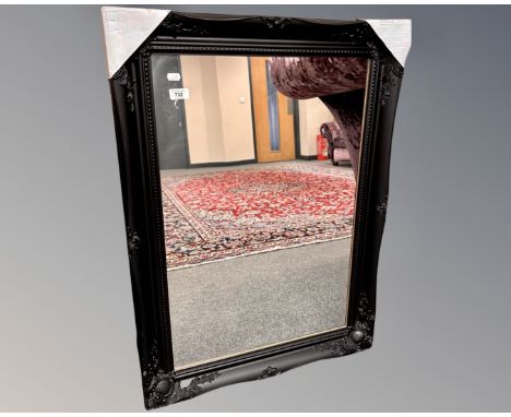 A contemporary black framed mirror, 66cm by 90cm.