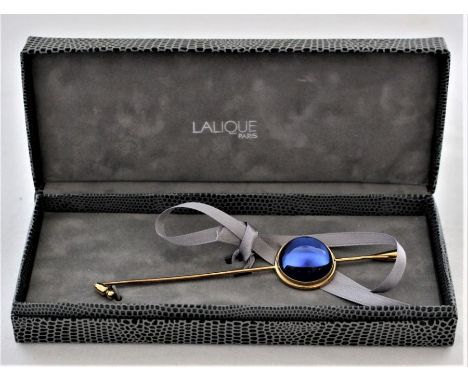 A Lalique gilt metal stick pin with blue glass cabochon, engraved "Lalique, Paris", in original box