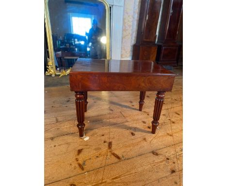 A Regency flamed mahogany bedside commode, the top enclosing ceramic commode bowl, raised on reeded supports.&nbsp;