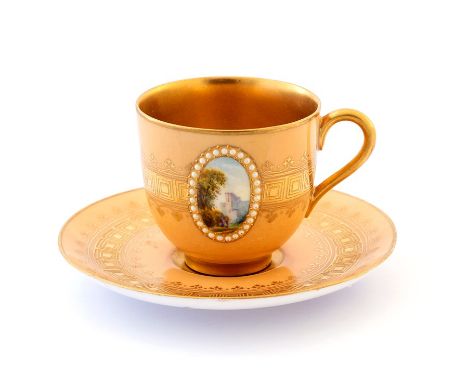 A Royal Worcester cabinet coffee cup and saucer, each piece painted with an oval view of a ruin within a jewelled border, gil