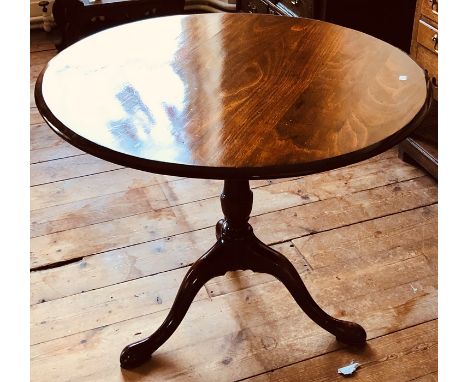 A George III mahogany tilt top occasional table, circa 1820, circular top, turned column on a tripod form saber feet