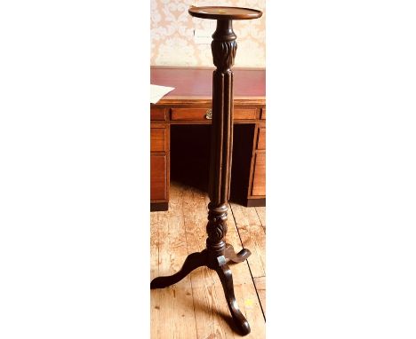 A George III mahogany jardinière stand, circa 1810, circular top, fluted column, raised on a tripod form with saber feet.