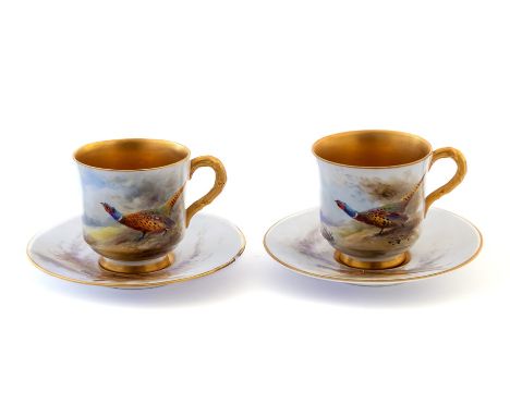 A pair of Royal Worcester cabinet coffee cups and saucers, painted with pheasants and singed James Stinton, gilt interiors, d