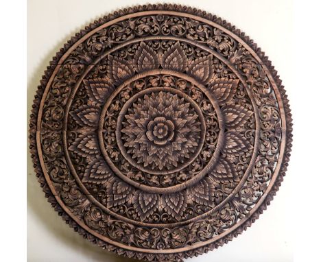 A circular carved and pierced Indian rosewood panel carved as a sunflower with multiple foliate and petal borders, 46 in. (11
