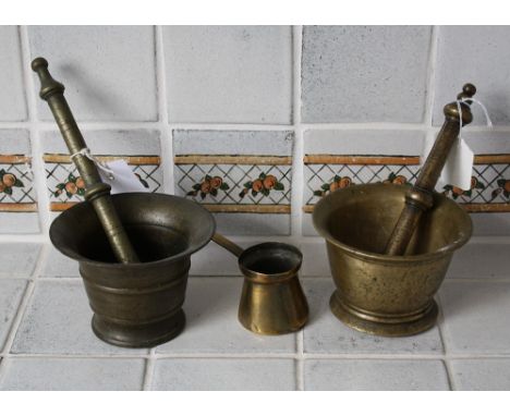 Two bronze pestles and mortars and a brass measure ladle. (5)