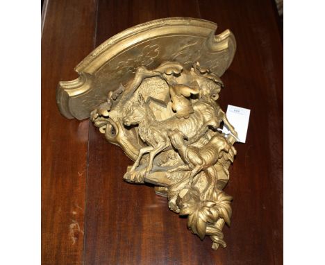 A Victorian style carved walnut wall bracket 20th century, gilt painted, carved with a goat and hunting dog amidst oak branch