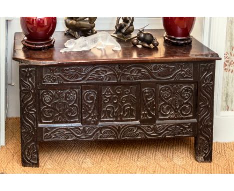 An 18th century three panel carved oak coffer with good patina and colour, the three plank top over a front with 17th century