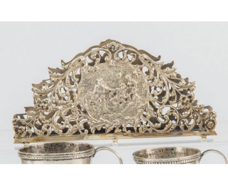 A Dutch silver letter rack c.1900, of arched form with pierced foliate sides centred with tavern scenes, on a ladder form bas