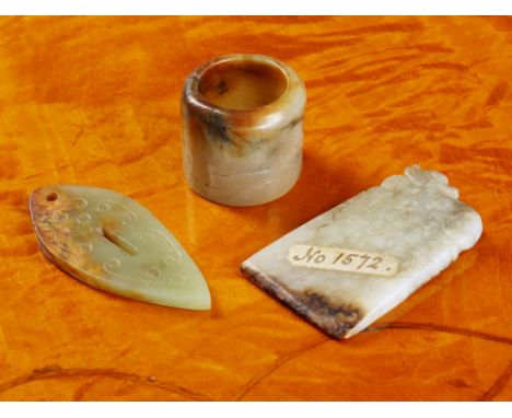 A Chinese jade archer's ring 17th / 18th century, in pale grey jade with russet and dark grey inclusions, engraved with a bix