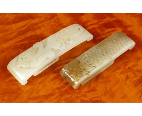 Two antique Chinese carved jade sword slides possibly Han Dynasty (206BC-220AD), one very pale green jade, engraved in relief
