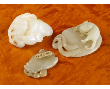 Three antique Chinese carvings comprising a very pale green jade figure of a cat lying upon a water lily leaf, 5.5cm. long; a